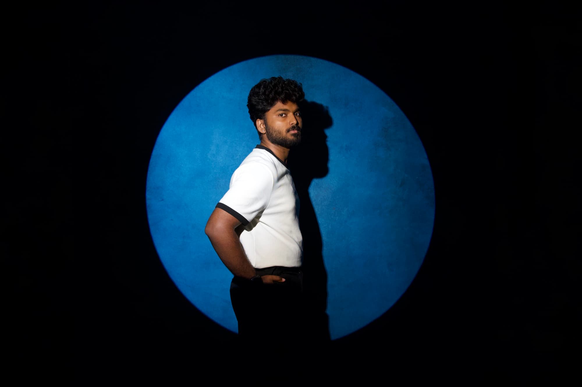 Ajay Nathan standing in a circle of blue light