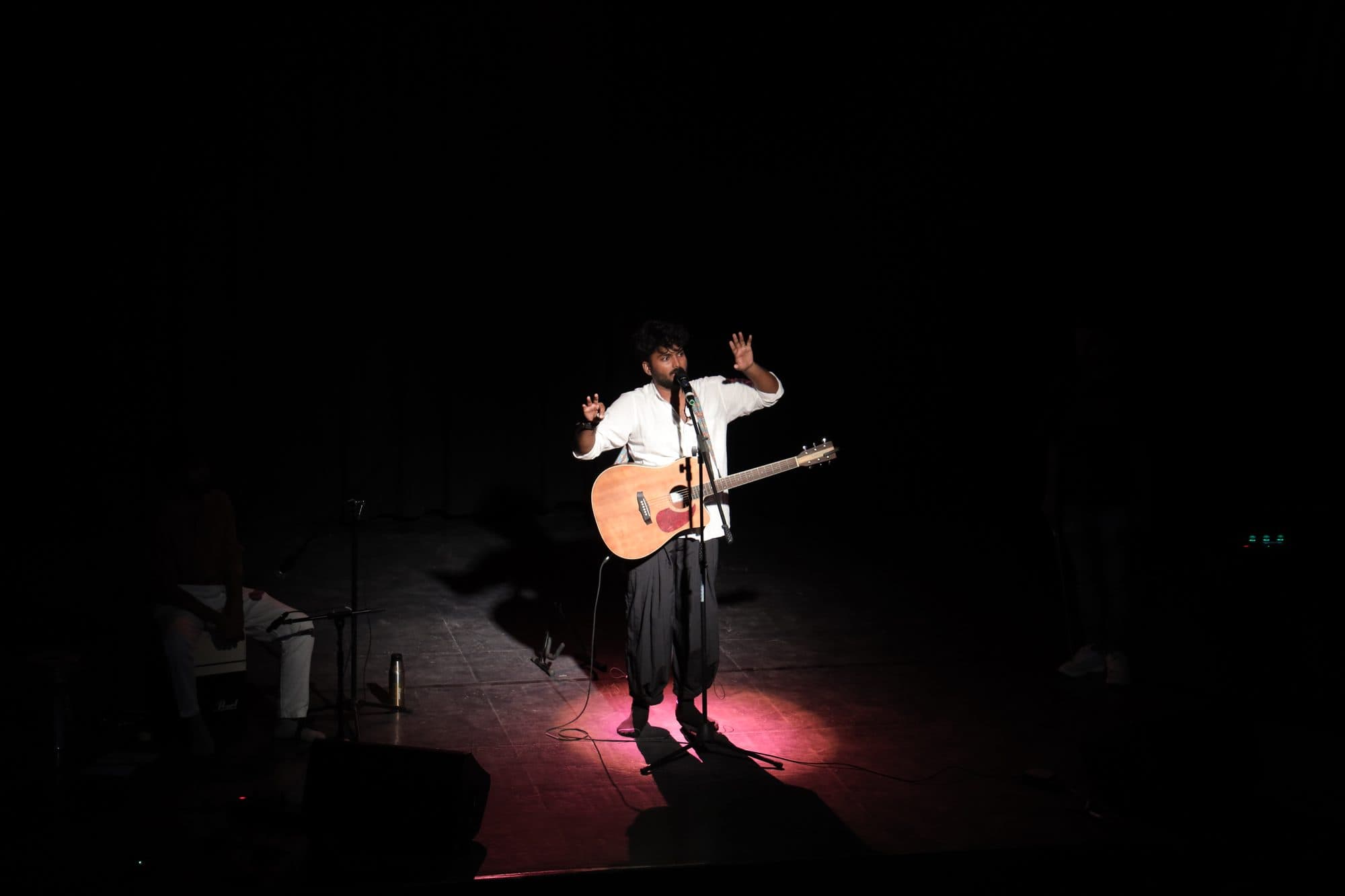 Ajay Nathan under a spotlight on stage