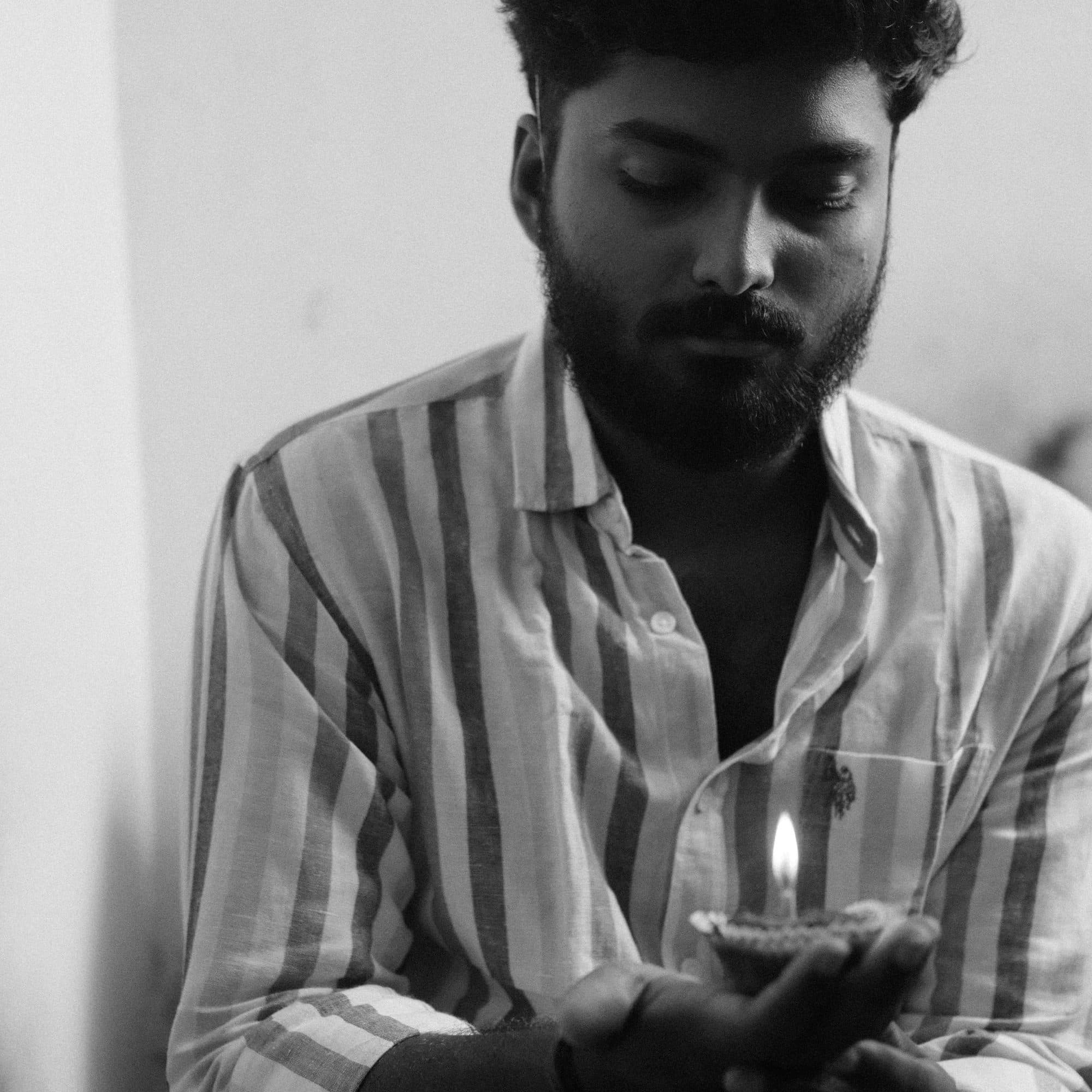 Ajay Nathan holding a lamp, black and white portrait